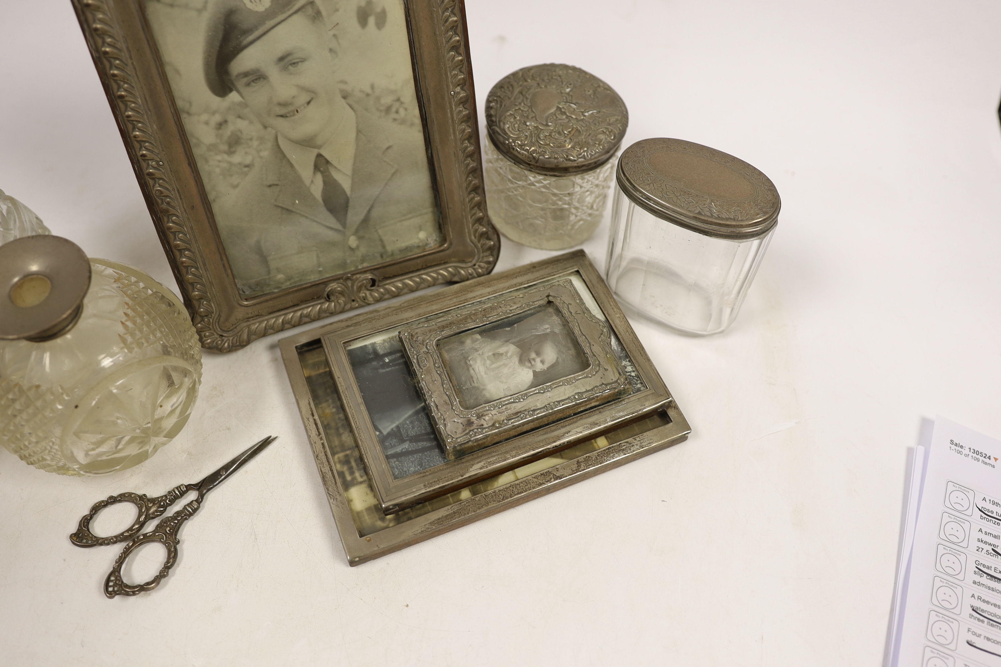 Four assorted early 20th century silver mounted photograph frames, largest 19.5cm (a.f.) five assorted silver mounted glass toilet jars and a small pair of silver handled scissors.